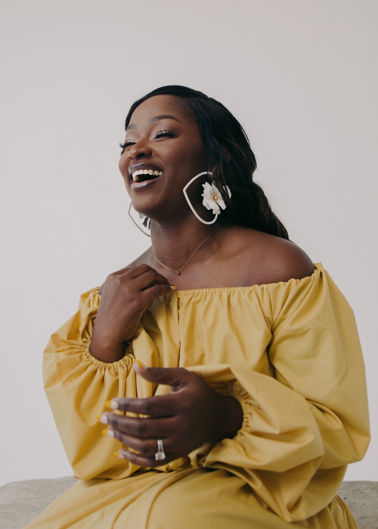 Ejiro Obayomi laughing in a yellow dress
