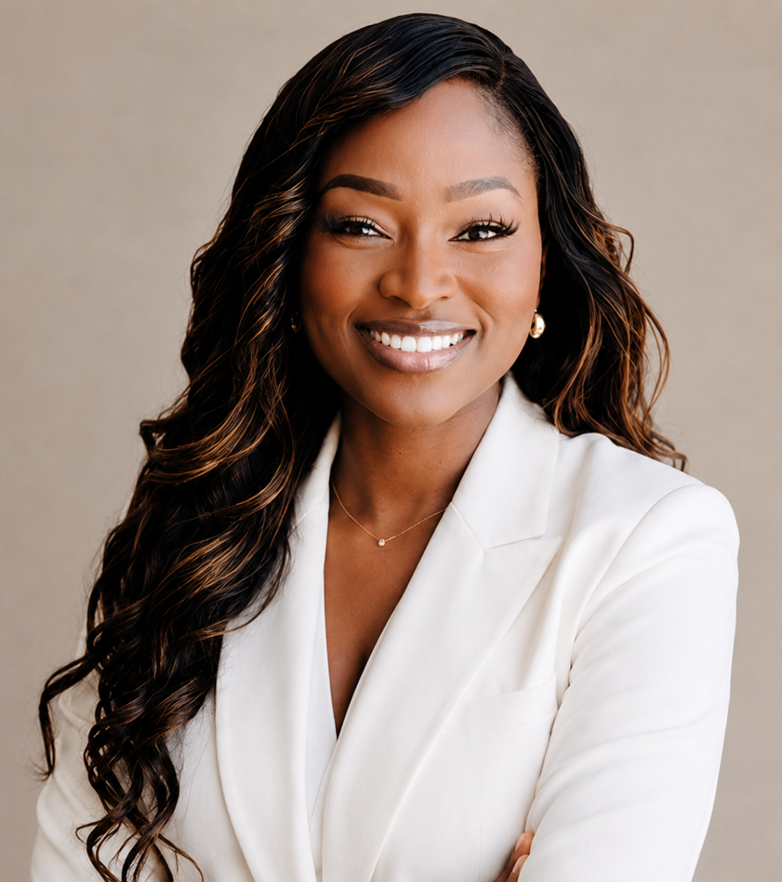 Ejiro Obayomi in a white suit with folded arms and a bright smile