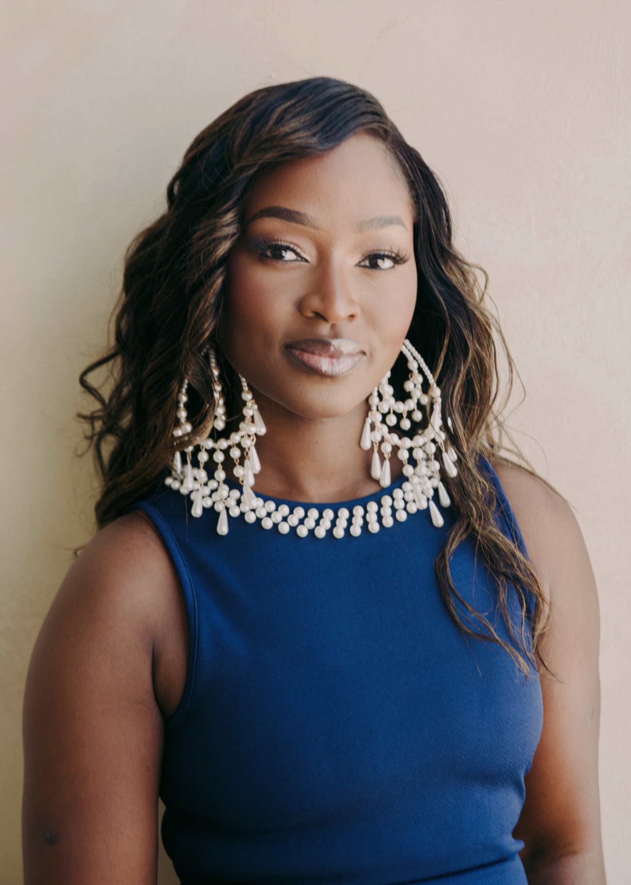 Ejiro Obayomi in a blue dress with statement pearl earrings